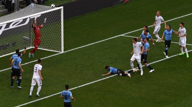 Penjaga gawang Rusia Igor Akinveef mematahkan peluang pemain Uruguay dalam pertandingan yang digelar di Samara Arena, Senin (25/6/2018) [AFP]