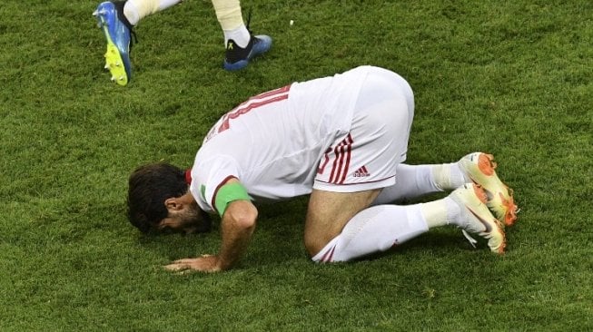 Penyerang pengganti Timnas Iran, Karim Ansarifard melakukan sujud syukur usai menjebol gawang Portugal lewat titik putih (Mladen ANTONOV / AFP)