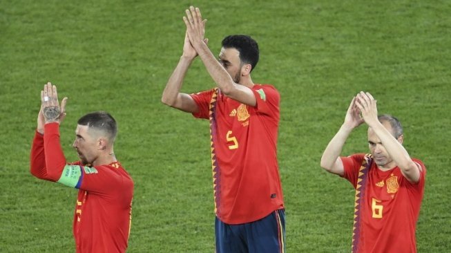 Pemain Spanyol Sergio Ramos (kiri), Sergio Busquets (tengah) dan Iniesta memberikan aplaus kepada suporternya usai bermain melawan Maroko. OZAN KOSE / AFP