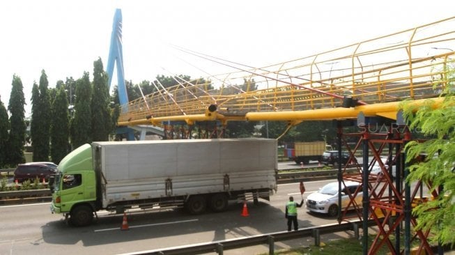 Kendaraan melintas di bawah jembatan penyebrangan orang (JPO) yang rusak di Tol Bambu Apus-Pondok Indah, JORR KM 34, Jakarta, Sabtu (30/6). 