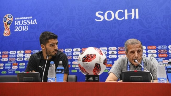 Pelatih Timnas Uruguay, Oscar Tabarez (kanan), didampingi anak asuhnya, Luis Suarez, dalam konferensi pers jelang laga melawan Portugal di 16 Besar Piala Dunia 2018, Jumat (29/6). [AFP/Jonathan Nackstrand]