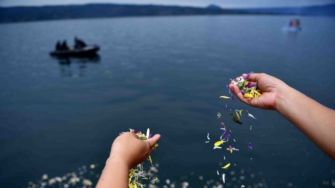 Keluarga korban tenggelamnya KM Sinar Bangun menabur bunga di kawasan titik tenggelamnya kapal di Danau Toba, Sumatera Utara, Senin (2/7). 