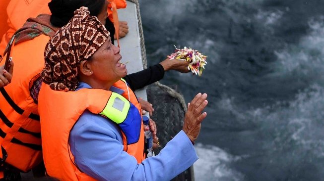 Keluarga korban tenggelamnya KM Sinar Bangun memanjatkan doa dalam prosesi tabur bunga di kawasan titik tenggelamnya kapal di Danau Toba, Sumatera Utara, Senin (2/7). 