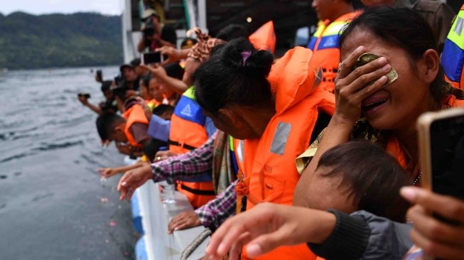 Keluarga korban tenggelamnya KM Sinar Bangun menangis saat prosesi tabur bunga di kawasan titik tenggelamnya kapal di Danau Toba, Sumatera Utara, Senin (2/7).