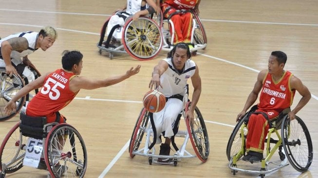 Pebasket kursi roda Indonesia Donald Putra Santoso (kiri) dan Gusti Putu Putra Adyana (kanan) mencoba menghadang laju pebasket Thailand Tawatchai Jiasin pada ajang Indonesia Para Games Invitational Tournament di Kompleks Gelora Bung Karno, Senayan, Jakarta, Senin (2/7).