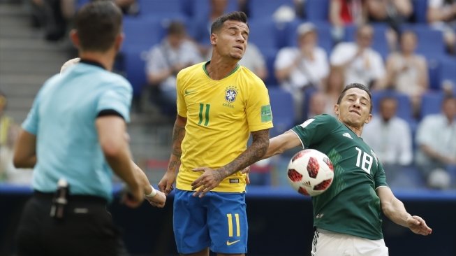 Gelandang andalan Timnas Brasil, Philippe Coutinho (tengah) berduel udara dengan gelandang Meksiko, Andres Guardado (kanan) (Anadolu Agency)