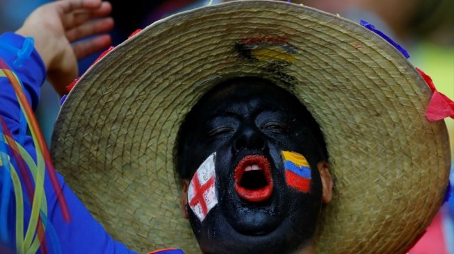 Seorang fans mengecat pipinya dengan bendera Inggris dan Kolombia yang tengah bertanding di babak 16 Besar Piala Dunia 2018 di Otkritie Arena, Rusia, Rabu (4/7). [Anadolu]