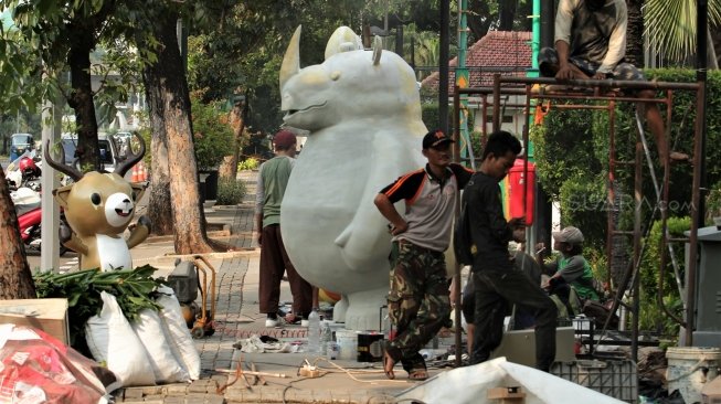 Para pekerja tampak menyelesaikan dan memasang maskot serta tulisan Asian Games 2018 di kawasan Balai Kota DKI, Jakarta, Kamis (5/7/2018). [Suara.com/Muhaimin A Untung]