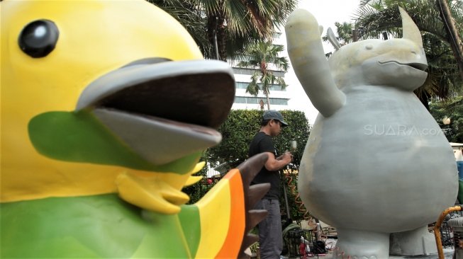 Para pekerja tampak menyelesaikan dan memasang maskot serta tulisan Asian Games 2018 di kawasan Balai Kota DKI, Jakarta, Kamis (5/7/2018). [Suara.com/Muhaimin A Untung]