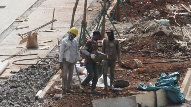 Sejumlah pekerja terlihat menyelesaikan proyek pembangunan dan penataan trotoar di Jalan Sudirman, Jakarta, Kamis (5/7/2018), menuju perhelatan Asian Games 2018. [Suara.com/Oke Atmaja]