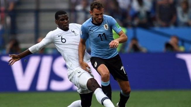 Gelandang Timnas Prancis, Paul Pogba berduel dengan penyerang Uruguay, Christian Stuani (Kirill KUDRYAVTSEV / AFP)