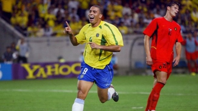 Striker Brasil, Ronaldo (kiri), merayakan golnya ke gawang Belgia saat kedua tim bertemu di 16 Besar Piala Dunia 2002. Tampak bek Belgia, Jacky Peeters (kanan), kecewa gawang timnya kebobolan. [AFP/Odd Andersen]