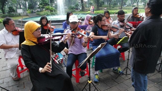 Belajar memainkan biola di Taman Menteng (Suara.com/Muhaimin A Untung)