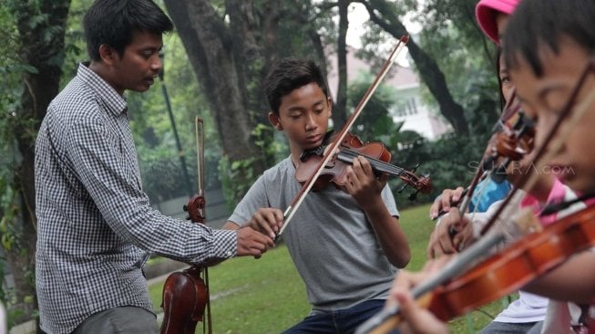 Belajar memainkan biola di Taman Menteng (Suara.com/Muhaimin A Untung)