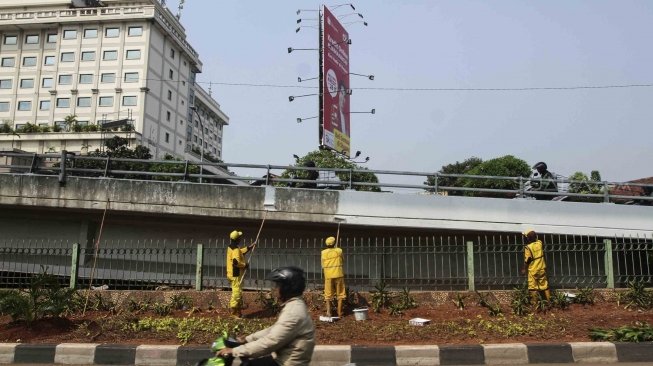 Sejumlah pekerja Suku Dinas Bina Marga Jaksel tampak mengecat jembatan flyover di Jalan Tendean, Jakarta Selatan, Senin (9/7/2018), sebagai perawatan rutin sekaligus menyambut Asian Games 2018. [Suara.com/Muhaimin A Untung]