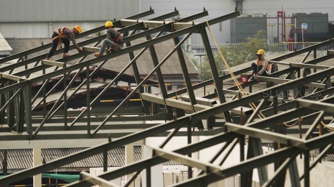 Sejumlah pekerja tampak mengerjakan proyek pembangunan Pasar Ikan Modern, di kawasan Muara Baru, Jakarta Utara, Selasa (10/7/2018). [Suara.com/Muhaimin A Untung]