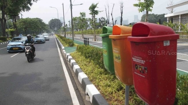 Suasana lalu lintas dan warga yang tampak berjalan di trotoar yang baru selesai direnovasi di Jalan Gerbang Pemuda Senayan, Jakarta, Selasa (10/7/2018). [Suara.com/Muhaimin A Untung]