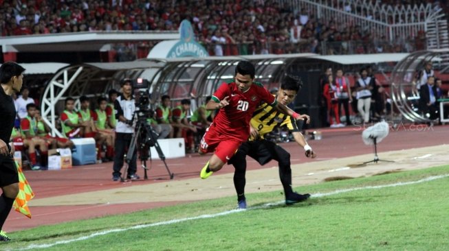 Winger Timnas Indonesia U-19, Asnawi Mangkualam (tengah), dijegal pemain Malaysia dalam pertandingan semifinal Piala AFF U-19 2018 di Stadion Gelora Delta, Sidoarjo, Jawa Timur, Kamis (12/7) malam. [Suara.com/Dimas Angga P]