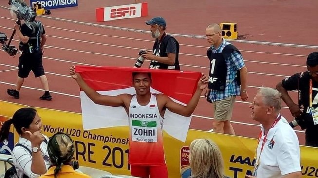 Pelari nasional, Lalu Muhammad Zohri, mengibarkan bendera Merah Putih usai menjuarai nomor lari 100 meter Kejuaraan Dunia Atletik U-20 di Tampere, Finlandia, Rabu (11/7/2018). [Dok. PASI] 