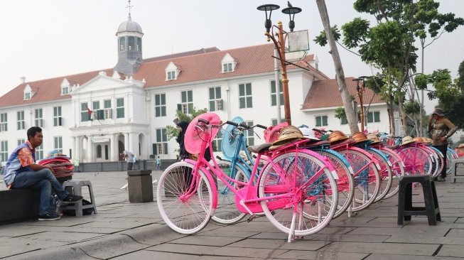 Meski belum bisa menjadi salah satu situs warisan dunia UNESCO, sejumlah pengunjung tampak beraktivitas di kawasan Kota Tua, Jakarta, Jumat (13/7/2018). [Suara.com/Oke Atmaja]