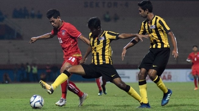 Pemain Timnas Myanmar U-19 Nan Htike Zaw (kiri) berebut bola dengan pemain Timnas Malaysia U-19 Muhammad Zahril Azri (tengah) dalam Final Piala AFF U-19 2018 di Stadion Gelora Delta, Sidoarjo, Jawa Timur [ANTARA FOTO/M Risyal Hidayat]