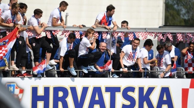 Para pemain Kroasia menyapa para pendukungnya yang menyambut mereka di Zagreb. ATTILA KISBENEDEK / AFP