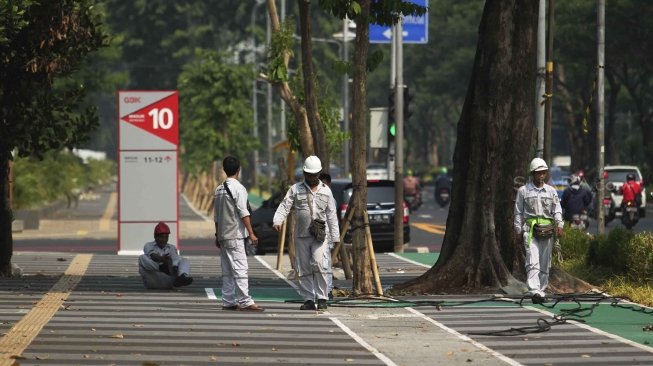 Pekerja Suku DInas Perindustrian dan Energi memperbaiki kabel perapian jaringan penerangan jalan umum di Pedestrian Kawasan Gelora Bung Karno (GBK), Jakarta, Selasa (17/7/2018).