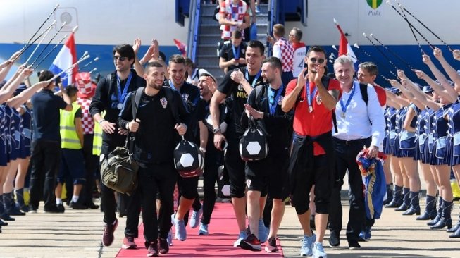 Para pemain Kroasia telah disambut meriah saat turun dari pesawat di Airbus 319 di Bandara Internasional Zagreb setelah kembali dari Rusia. ATTILA KISBENEDEK / AFP