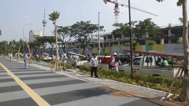 Pekerja Suku DInas Perindustrian dan Energi memperbaiki kabel perapian jaringan penerangan jalan umum di Pedestrian Kawasan Gelora Bung Karno (GBK), Jakarta, Selasa (17/7/2018).