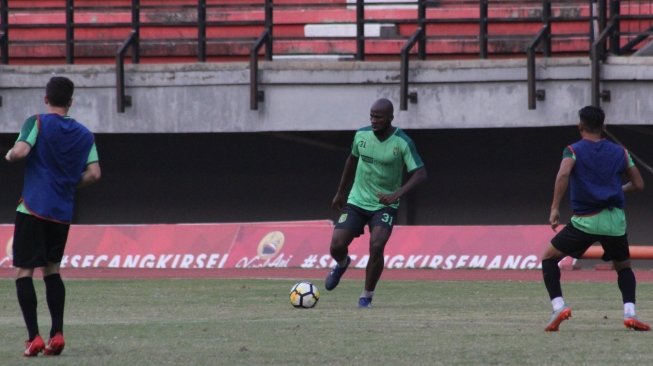 Bek anyar Persebaya Surabaya, Onorionde Kughegbe John (tengah) melakukan sesi latihan. (Suara.com/Dimas Angga P) 