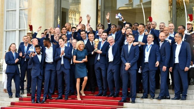 Presiden Prancis Emmanuel Macron (tengah) menyambut kepulangan para pemain Timnas Prancis yang menjuarai Piala Dunia 2018 di Istana Elysee, Paris, Senin (16/7/2018). [Anadolu]
