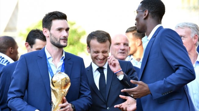 Presiden Prancis Emmanuel Macron (tengah) menyambut kepulangan para pemain Timnas Prancis yang menjuarai Piala Dunia 2018 di Istana Elysee, Paris, Senin (16/7/2018). [Anadolu]