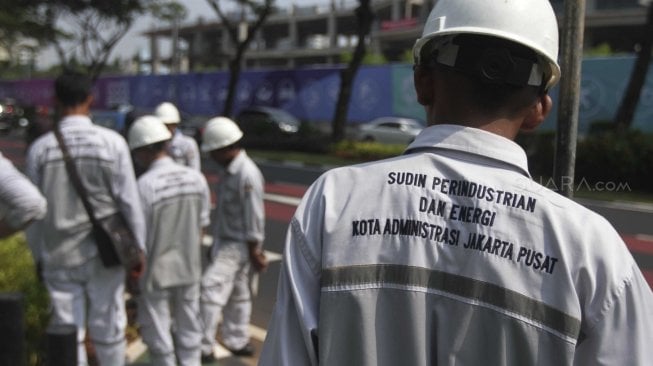 Pekerja Suku DInas Perindustrian dan Energi memperbaiki kabel perapian jaringan penerangan jalan umum di Pedestrian Kawasan Gelora Bung Karno (GBK), Jakarta, Selasa (17/7/2018).