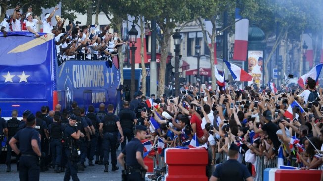 Para pemain Timnas Prancis diarak dengan bus terbuka menuju Istana Elysee usai menjuarai Piala Dunia 2018, Senin (16/7/2018). [Anadolu]
