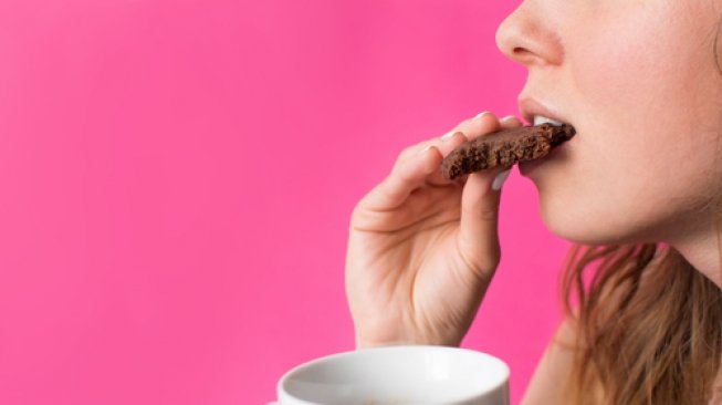 Ilustrasi mengonsumsi makanan manis, camilan, cookies. (Shutterstock)