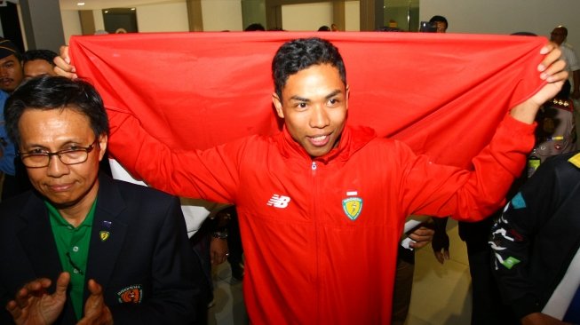 Atlet Indonesia juara dunia atletik nomor Lari 100 meter U-20 Lalu Muhammad Zohri  membentangkan Bendera Merah Putih setibanya dari Finlandia di Bandara Internasional Soekarno Hatta, Tangerang, Banten, Selasa (17/7). Lalu Muhammad Zohri menjadi Juara atletik nomor Lari 100 meter putra Kejuaraan Dunia IAAF U-20 2018 di Finlandia. ANTARA FOTO/Muhammad Iqbal