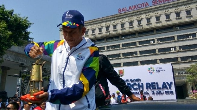 Yustedjo Tarik, mantan petenis putra Indonesia bersama api abadi yang diarak [Suara.com/Adam Iyasa].