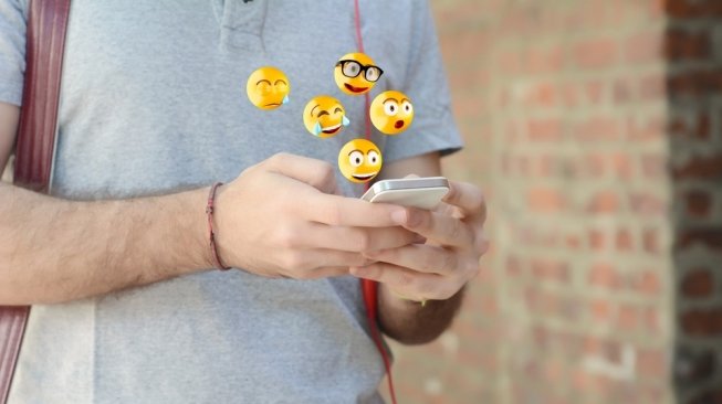 Ilustrasi seorang lelaki chat menggunakan emoji. [Shutterstock]