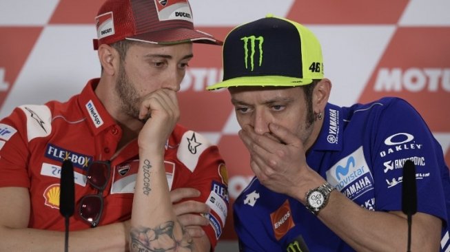 Pebalap Ducati, Andrea Dovizioso (kiri) berbincang dengan kompatriotnya dari Italia, Valentino Rossi (Movistar Yamaha). [AFP/Juan Mabromata]