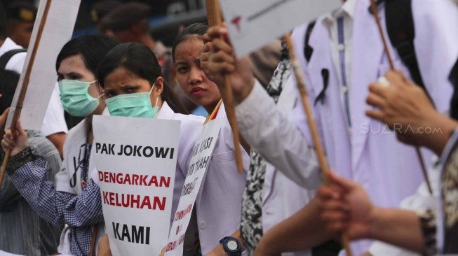 Ratusan orang yang tergabung dalam Pergerakan Dokter Muda Indonesia melakukan aksi di depan Taman Aspirasi Monas, Jakarta, Jumat (19/7). Dalam aksinya mereka meminta agar Kemeristekdi mengeluarkan ijazah Dokter yang disita.[suara.com/Muhaimin A Untung]
