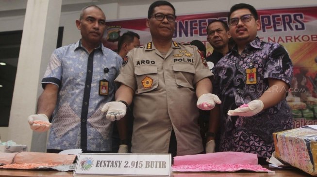 Kabid Humas Polda Metro Jaya Kombes Argo Yuwono (tengah) bersama petinggi Ditresnarkoba Polda Metro Jaya mengikuti pemusnahan barang bukti narkotika jenis ekstasi di Kantor Ditresnarkoba Polda Metro Jaya, Jumat (20/7/2018). [Suara.com/Muhaimin A Untung]