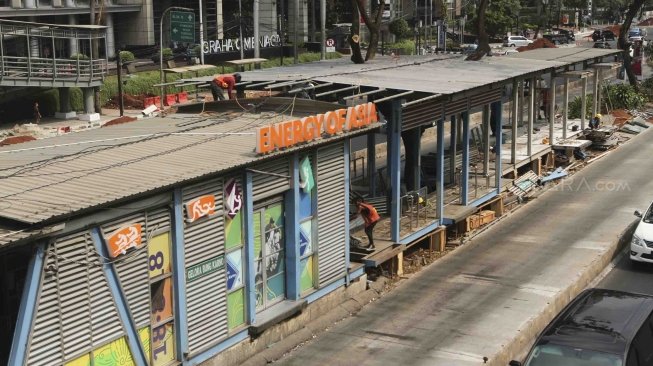 Sejumlah pekerja terlihat menyelesaikan pembangunan perluasan halte Transjakarta Gelora Bung Karno (GBK) di Jalan Sudirman, Jakarta, Jumat (20/7/2018). [Suara.com/Muhaimin A Untung]