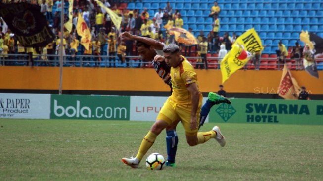 Gelandang Sriwijaya FC, Esteban Vizcarra (depan) mendapat pengawalan dari pemain Arema dalam laga yang berakhir 0-3 untuk kemenangan Arema di Stadion Gelora Sriwijaya Jakabaring, Palembang, Sabtu (21/7/2018). [Suara.com/Andhiko Tungga Alam]