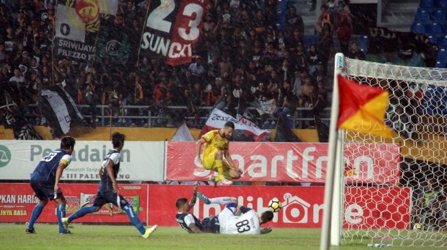 Penjaga Gawang Arema FC, Srdan Ostojic (kanan), menghadang serangan pemain Sriwijaya FC dalam laga yang berakhir 0-3 untuk kemenangan Arema di Stadion Gelora Sriwijaya Jakabaring, Palembang, Sabtu (21/7/2018). [Suara.com/Andhiko Tungga Alam]