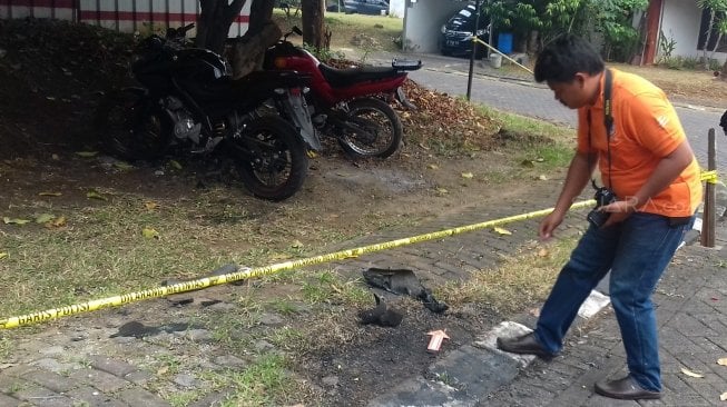 Anggota tim Inafis Polresta Depok melakukan olah tempat kejadian perkara (TKP) terkait terbakarnya mobil Neno Warisman di Perumahan Griya Tugu Asri Blok B2 Nomer 4 Kecamatan Cimanggis Kota Depok, Jawa Barat, Sabtu (21/7/2018). [Suara.com/Supriyadi]