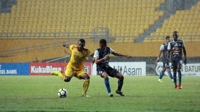 Pesepakbola Sriwijaya FC, Marckho Sandy Merauje (kiri) berebut bola dengan pemain Arema dalam laga yang berakhir 0-3 untuk kemenangan Arema di Stadion Gelora Sriwijaya Jakabaring, Palembang, Sabtu (21/7/2018). [Suara.com/Andhiko Tungga Alam]