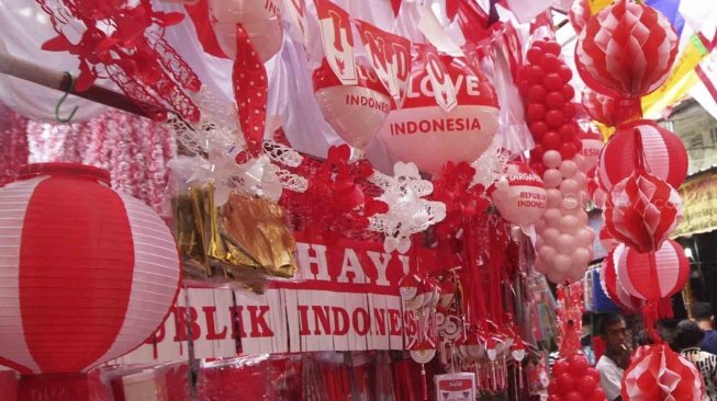 Penjual memajang bendera dan pernak-pernik bernuansa merah putih di Pasar Jatinegara, Jakarta, Senin (23/7). Bendera dan pernak-pernik yang dijual dengan harga Rp. 20 ribu hingga Rp. 500 ribu tergantung ukuran dan jenis bahan tersebut mulai marak dijual menjelang peringatan Hari Kemerdekaan Indonesia pada 17 Agustus. [Suara.com/Muhaimin A Untung]