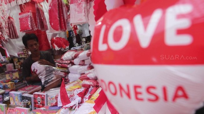 Penjual memajang bendera dan pernak-pernik bernuansa merah putih di Pasar Jatinegara, Jakarta, Senin (23/7). Bendera dan pernak-pernik yang dijual dengan harga Rp. 20 ribu hingga Rp. 500 ribu tergantung ukuran dan jenis bahan tersebut mulai marak dijual menjelang peringatan Hari Kemerdekaan Indonesia pada 17 Agustus. [Suara.com/Muhaimin A Untung]