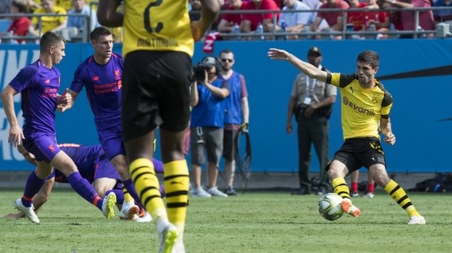 Pemain Borussia Dortmund Christian Pulisic mencoba melewati hadangan dua pemain Liverpool dalam pertandingan International Champions Cup, Senin (23/7/2018) [AFP]