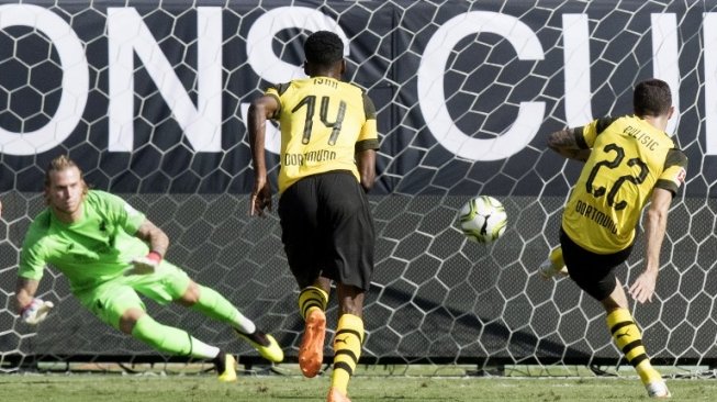 Pemain Borussia Dortmund Christian Pulisic menjebol gawang Liverpool yang dikawal Loris Karius dalam pertandingan International Champions Cup, Senin (23/7/2018) [AFP]